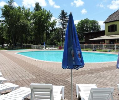 Piscine extérieure avec transats et parasols au Camping Les Lupins