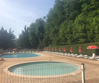 Piscine extérieure et pataugeoire avec transats et parasols au Camping Les Lupins