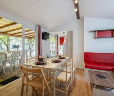 Intérieur avec coin repas et terrasse couverte du Camping Les Mizottes