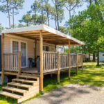 Mobil-home et terrasse ombragée dans la pinède au Camping Les Oyats