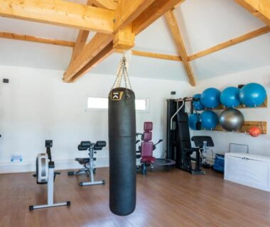 Salle de sport intérieure avec sac de boxe et matériel de fitness au Camping Les Oyats