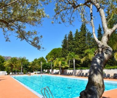 Piscine extérieure bordée de transats au Camping Les Pêcheurs - Maeva