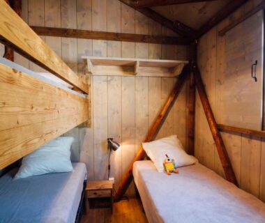 Chambre en bois avec deux lits simples dans le Camping Les Pins Bord de mer
