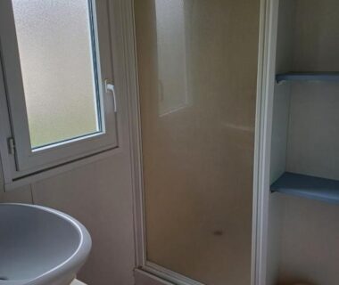 Salle de bain avec cabine de douche et lavabo au Camping Les Rives du Céou
