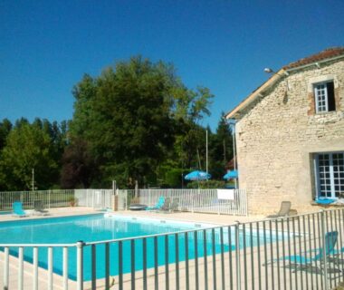 Piscine extérieure et bâtiment en pierre au Camping Les Rives du Céou
