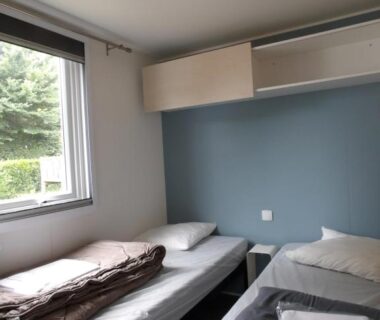 Chambre avec deux lits simples et fenêtre au Camping Les Sables Blancs