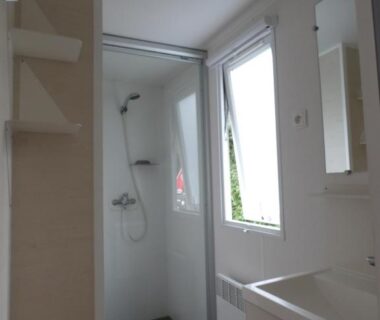 Salle de bain compacte avec douche cabine et lavabo du Camping Les Sables Blancs
