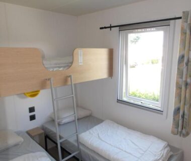 Chambre avec lits superposés et lits simples au Camping Les Sables Blancs