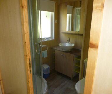 Salle de bain avec douche et lavabo au Camping Les Terrasses de Dordogne
