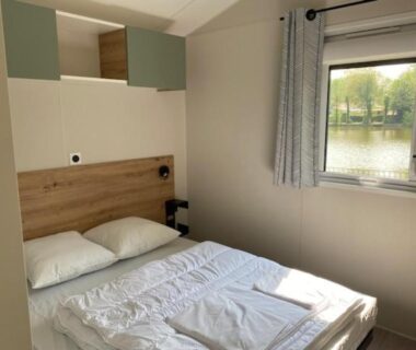 Chambre double avec fenêtre donnant sur l'étang au Camping Les Tourterelles