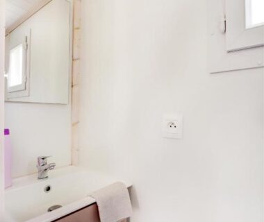 Salle de bains avec lavabo et miroir au Camping Les Vernieres La Bourboule Sancy