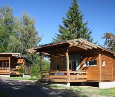 Terrasse de chalets en bois au Camping Les Vernieres La Bourboule Sancy
