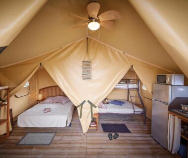 Intérieur de tente avec lits et kitchenette au Camping Les Vertes Feuilles