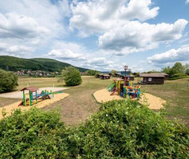 Aire de jeux extérieure avec structures et toboggans dans le Camping Les Vosges du Nord