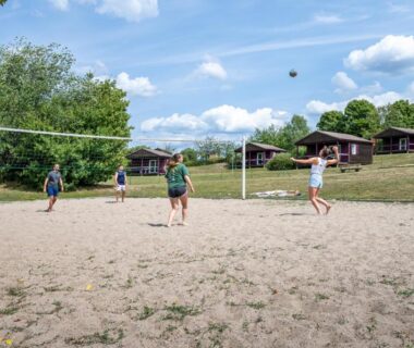 Terrain de volley sur sable avec joueurs au Camping Les Vosges du Nord