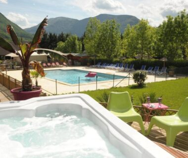 Terrasse avec jacuzzi et piscine extérieure au Camping L'imprévu