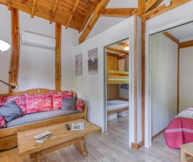 Séjour avec canapé et lits superposés du Camping L'imprévu