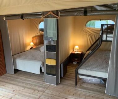 Intérieur de tente avec lit double et lits superposés au Camping L'oasis Du Berry