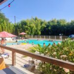 Piscine extérieure avec chaises longues et parasols au Camping L'oasis Du Berry