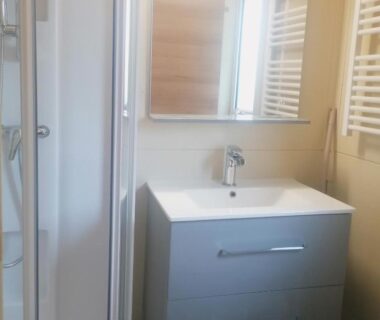 Salle de bains avec lavabo miroir douche et sèche-serviettes du Camping L'oasis Du Berry