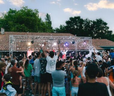 Espace extérieur avec foule dansant devant scène et mousse au Camping Lou Broustaricq