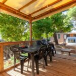 Terrasse couverte avec table et chaises au Camping Lou Soulei 218