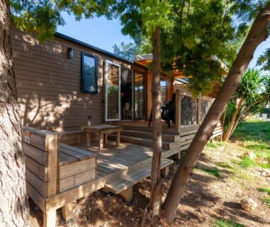 Terrasse ombragée en bois devant un mobil home au Camping Lou Soulei 218