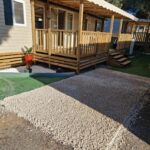 Allée gravillonnée et mobil-homes avec terrasses en bois du Camping Mar Estang