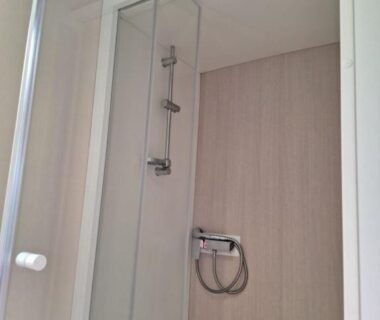 Cabine de douche avec pommeau et porte coulissante au Camping Mar Estang
