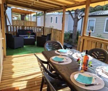 Terrasse couverte avec table à manger et coin salon au Camping Mar Estang