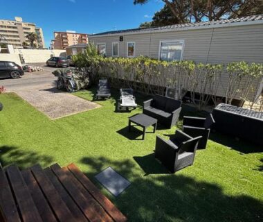 Espace extérieur avec salon de jardin et table en bois devant mobil-home au Camping Mar Estang