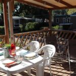 Terrasse couverte avec table dressée et chaises au Camping Mas De Pierredon