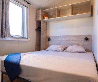 Chambre double avec fenêtre et étagères au Camping Mas du Padre