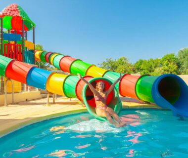 Piscine extérieure avec toboggans colorés au Camping Mas du Padre