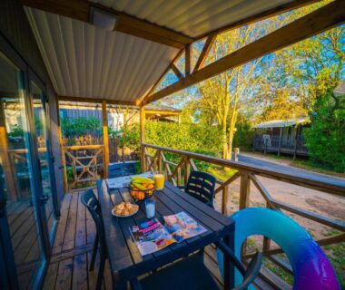 Terrasse couverte avec table chaises et bouée au Camping Mas du Padre