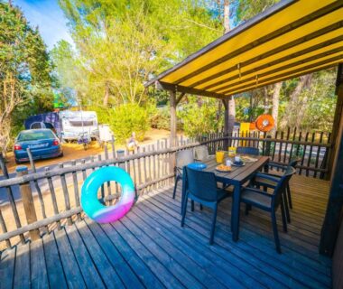 Terrasse en bois avec table et fauteuils au Camping Mas du Padre