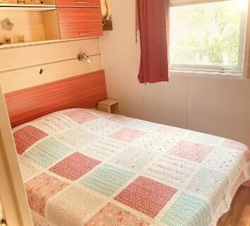 Chambre double avec lit et rangements au Camping Montana Parc 5 étoiles