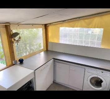 Cuisine compacte avec plan de travail et lave-linge dans l'hébergement du Camping Montana Parc 5 étoiles