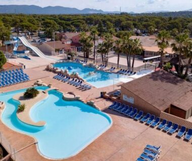 Espace piscine extérieur avec toboggans et transats au Camping Montana Parc