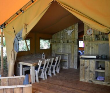 Intérieur de tente avec table et kitchenette au Camping Moulin De Chaules
