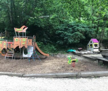 Aire de jeux avec toboggan et maisonnette au Camping Moulin De Chaules
