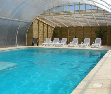 Piscine couverte avec transats au Camping Moulin de Collonge