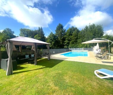 Pelouse avec piscine et tonnelle au Camping Moulin du Pommier