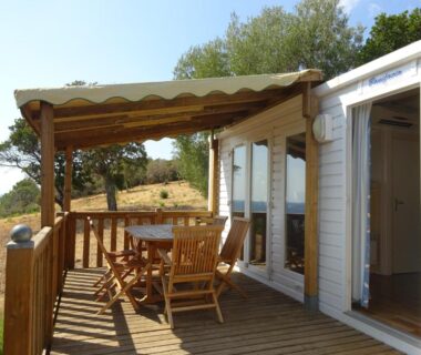 Terrasse en bois avec table et chaises au Camping Mozziconaccio