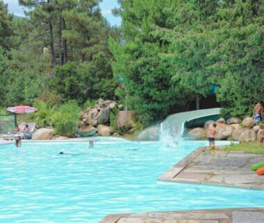 Piscine extérieure avec toboggan et parasols au Camping Mulinacciu