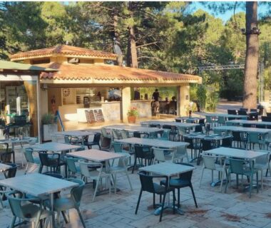 Terrasse extérieure avec tables et chaises au Camping Mulinacciu