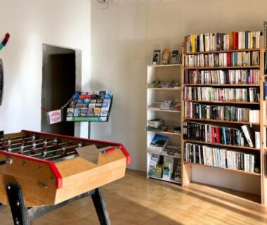Salle commune avec bibliothèque et baby-foot au Camping Naturiste Tikayan Petit Arlane