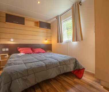 Chambre avec lit double et fenêtre au Camping New Rabioux
