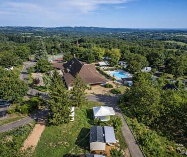 Vue aérienne du site avec piscine et hébergements au Camping O'Aka
