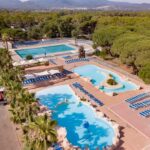 Complexe aquatique avec bassins et transats du Camping Oasis Village